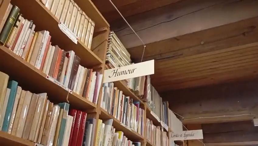 Rayonnage de livres dans la librairie Trouve-tout du Livre au Somail, section humour